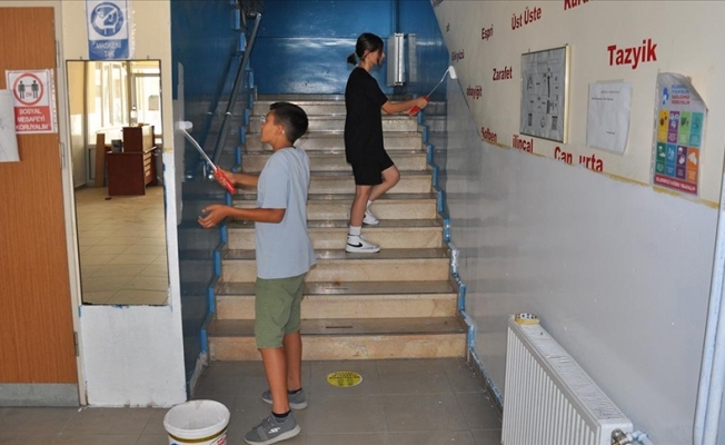 Müdür ve gönüllü öğrenciler okullarını boyuyor